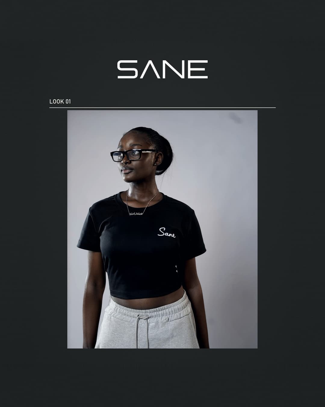 Model wearing the black Sane Crop Top with white script